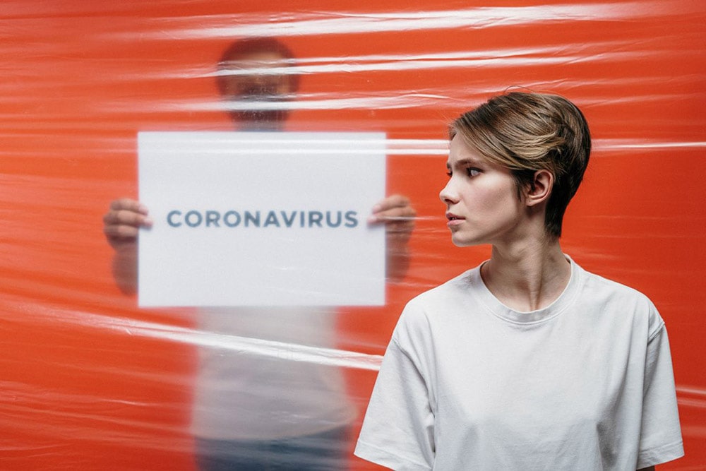 Pani patrzy na obrazek, na którym jest napisane coronavirus, czyli covid-19